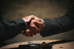 Two businessmen in suits shaking hands