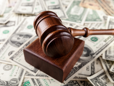 A judge’s gavel atop a pile of money, representing a plaintiff’s potential product liability damages